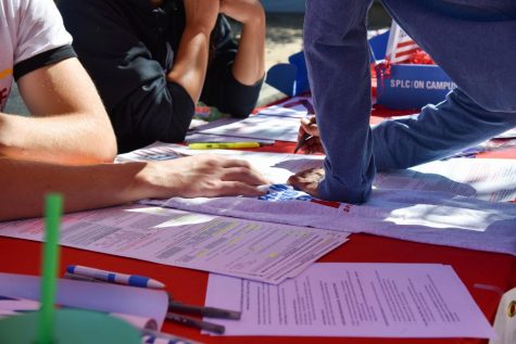 A student fills out registration papers during Political Awareness Day at Foothill College.