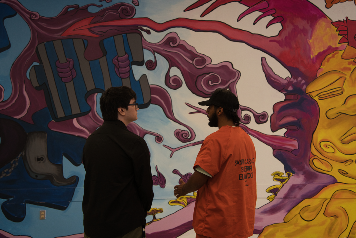 Jose discusses the mural with Script Lead Copyeditor Alex Martinez.