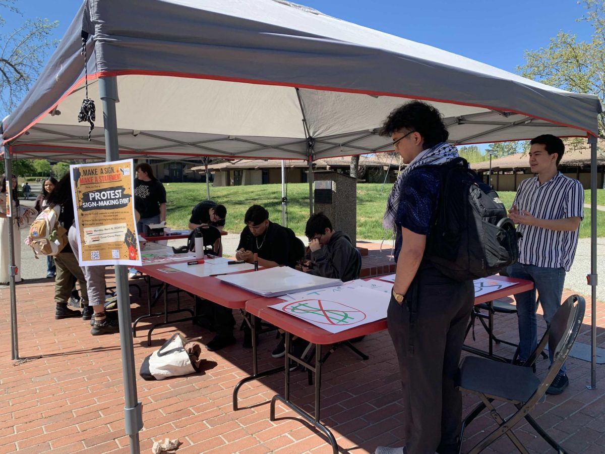 Students among others gather around Free Speech plaza to make their own protest signs 